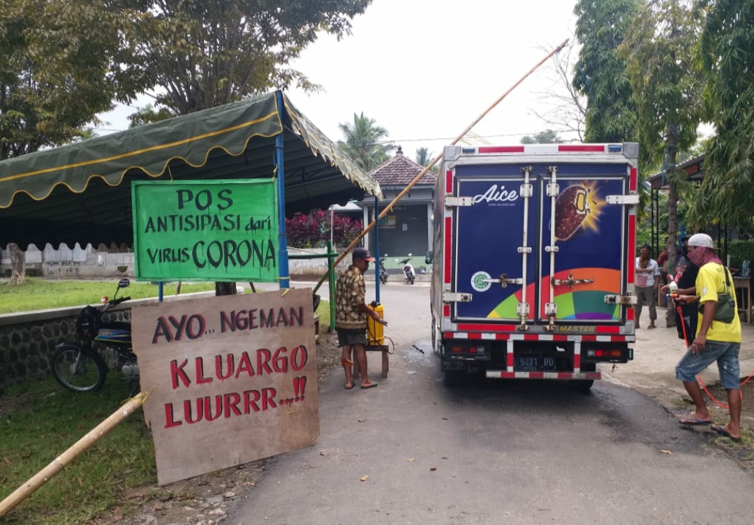 Warga Desa Wates Ponorogo saat melakukan penyemprotan disinfektan pada akses keluar masuk desa