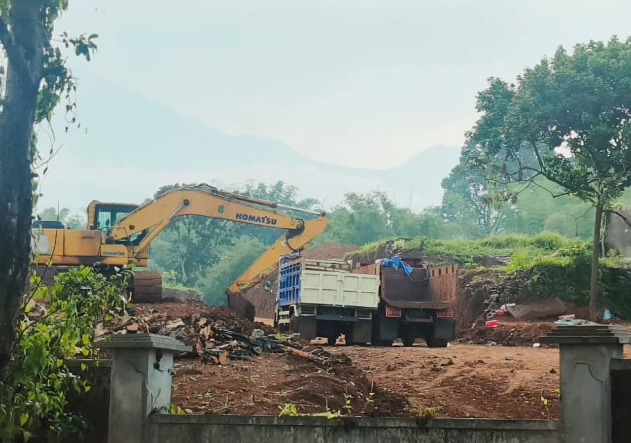 Dua alat berat dan truk mengangkut bahan material kegiatan cut and fill di lahan kawasan Sentul