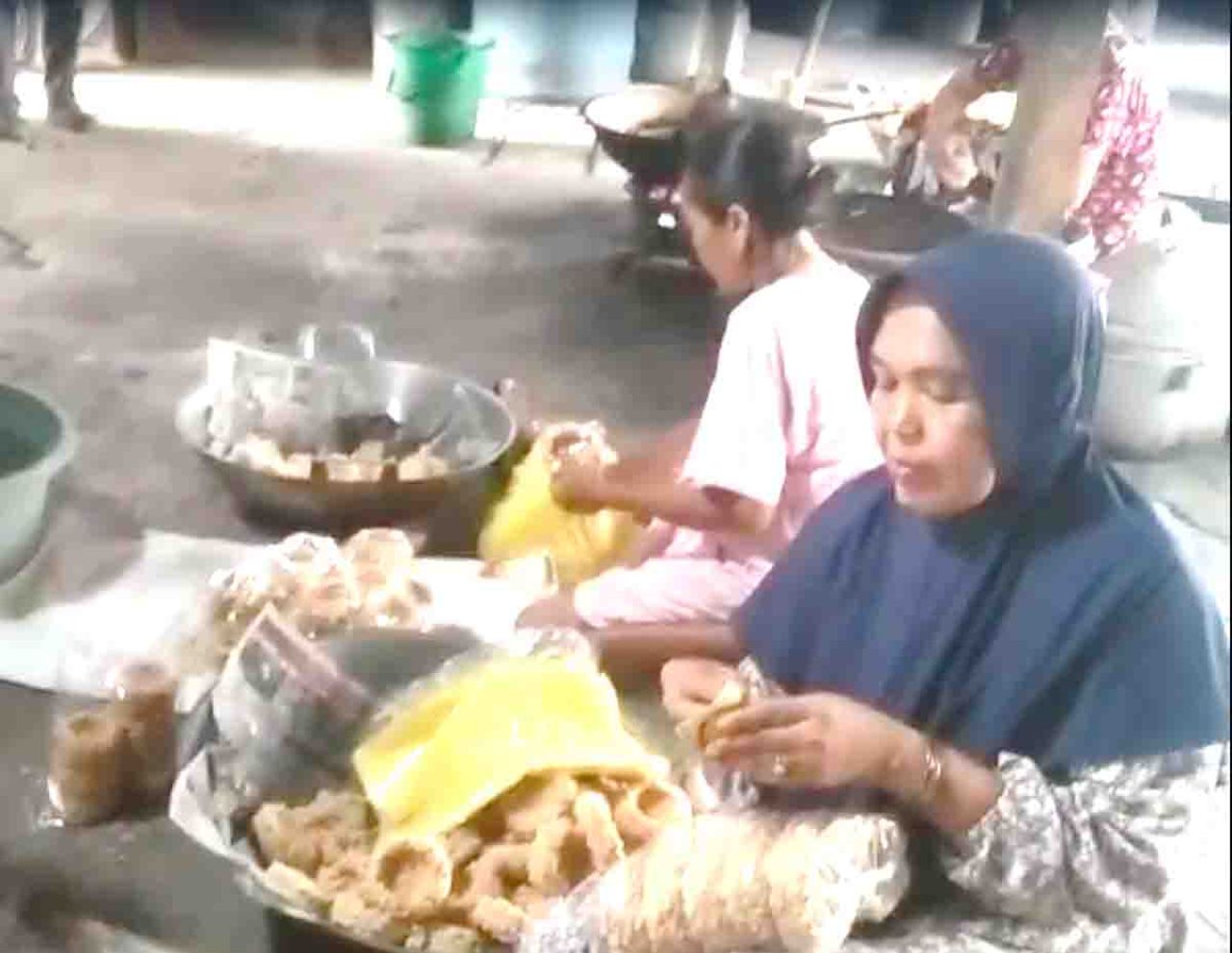 Ibu Siyem dibantu beberapa pekerja sedang mengemas rengginang