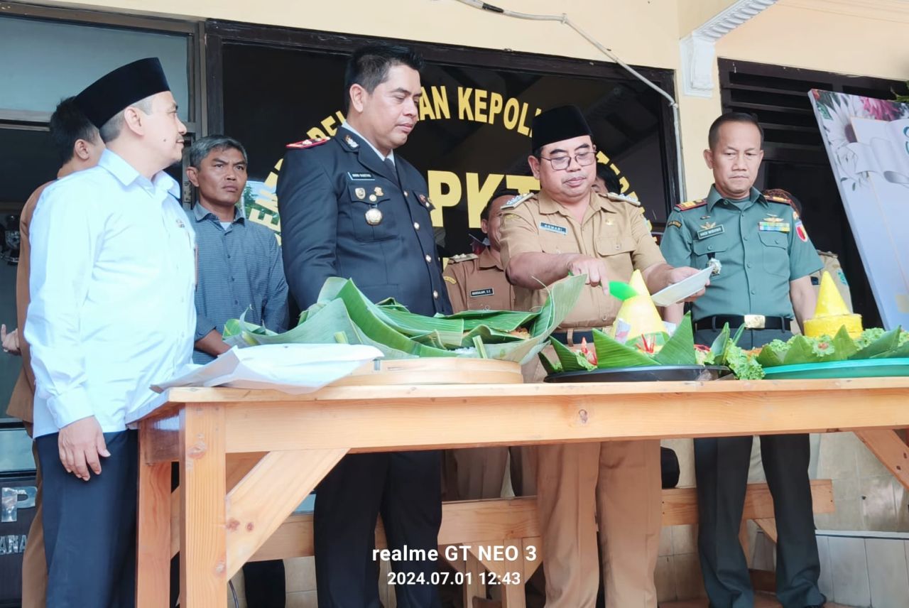 Camat Gempol Komari memberikan potongan tumpeng kepada Kapolsek Gempol Kompol Indro Sesetiyo mengucapkan HUT Bhayangkara ke -78