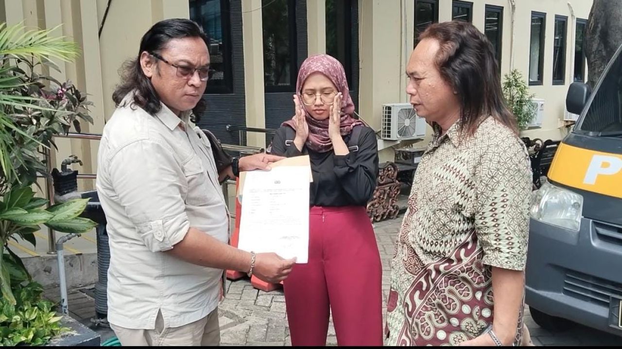 Dodik Firmansyah menunjukkan bukti lapor dari Polda Jatim