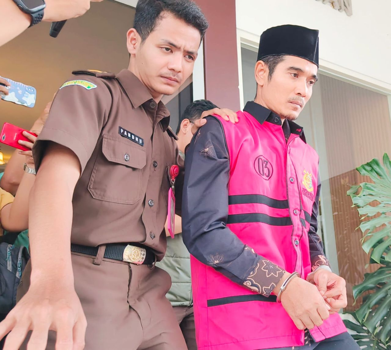 Erwin Setiawan oknum Pegawai Tidak Tetap dilingkup Dispendik Kabupaten Pasuruan ditetapkan tersangka langsung digelandang petugas ke mobil tahanan