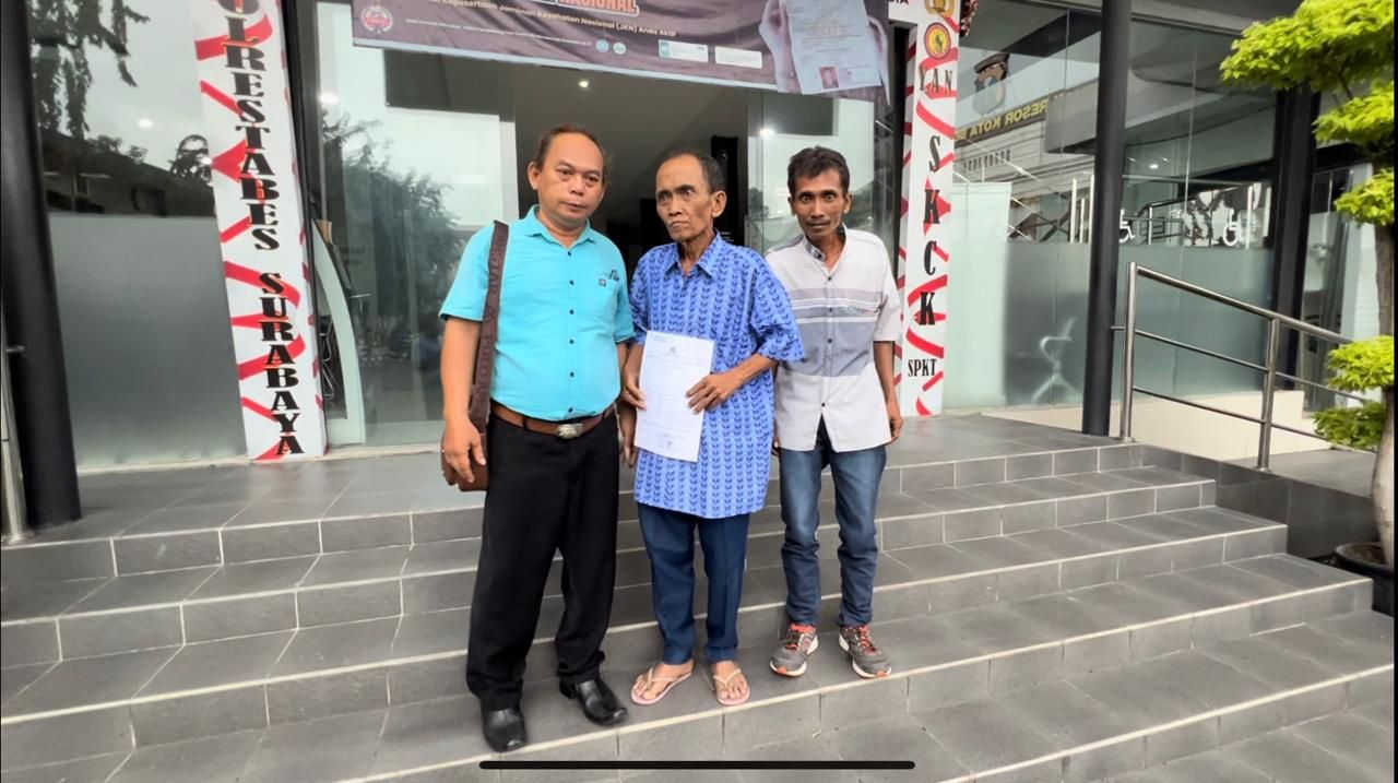 Soejatno (kemeja biru) didampingi Sukardi (kiri) usai laporan di Polrestabes Surabaya