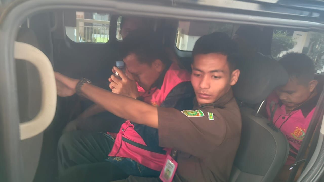 Ketiga orang memakai rompi tahanan kejaksaan digelandang ke mobil tahanan usai diperiksa sebagai tersangka