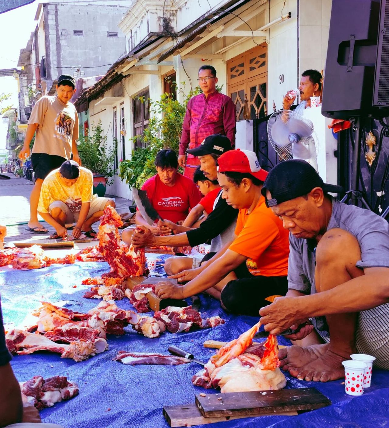 Dimas Prasetya (berdiri kiri atas pakai topi) bersama warga saat memotong daging kurban