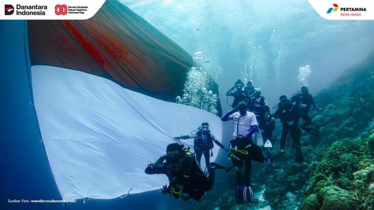 Bendera Merah Putih berkibar megah di bawah laut Wakatobi, Sulawesi Tenggara, dalam aksi peringatan HUT ke-80 RI yang diprakarsai Pertamina Patra Niaga bersama komunitas penyelam dan masyarakat lokal. (Foto: wonderscubawakatobi/ Pertamina Patra Niaga)