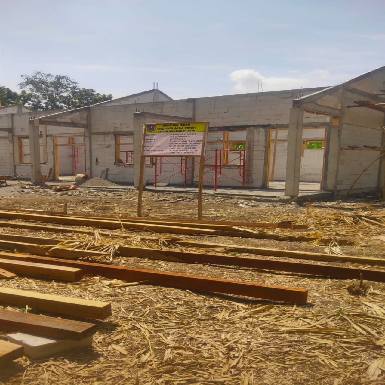 Papan proyek pembangunan MI “Perwanida” di Desa Kebondalem, Kecamatan Bareng, Jombang, yang baru terpasang setelah pemberitaan media.