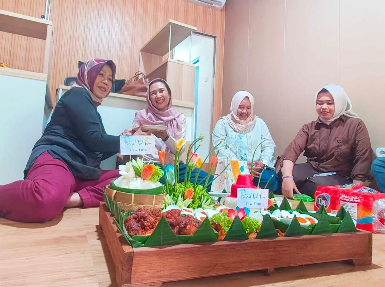 Elisa Andarwari pengacara senior sombolis memberika potongan nasi tumpeng kepada rekan sejawatnya Wiwik Tri Hariyati atas dibukannya kantor hukum