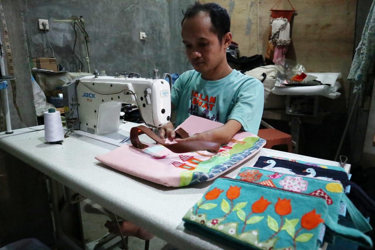 Akhmadi alias Ucil saat mengerjakan pesanan tas