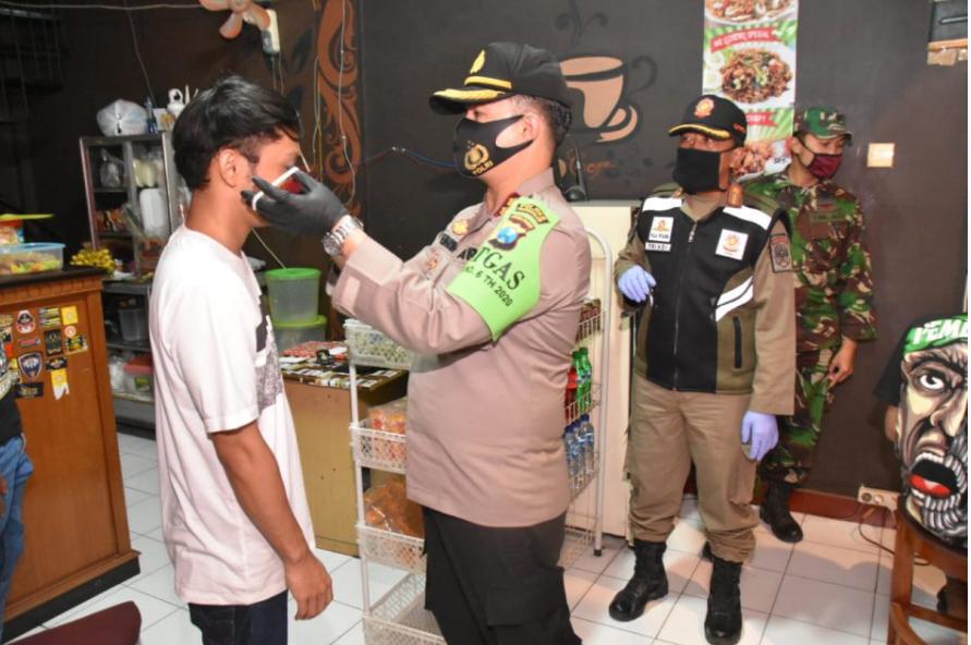 Kapolres Trenggalek AKBP Doni Satria Sembiring saat memakaikan masker kepada warga