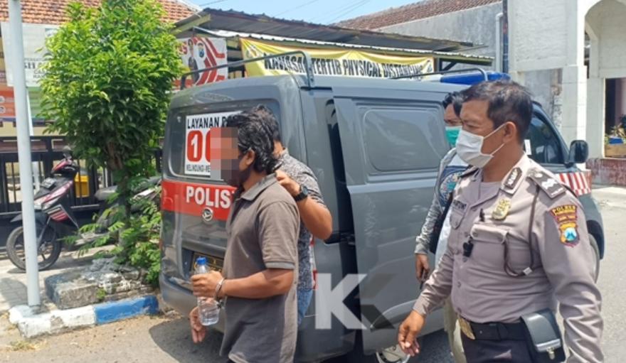 Tersangka ES saat di gelandang ke Polsek Kota Ponorogo