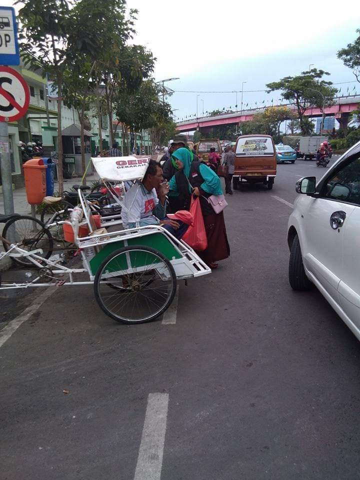 Sujasmitri (jaket ) saat membagikan nasi jumat berkah sebelum Ramadhan.