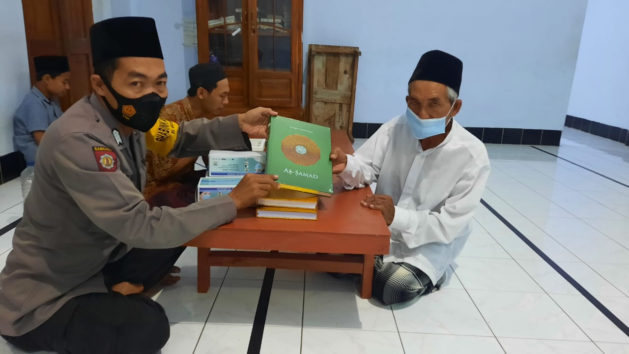 BRIPKA Pujiono Bhabinkamtibmas Desa Gelanglor Sukorejo  menyerahkan  Alquran dan Masker