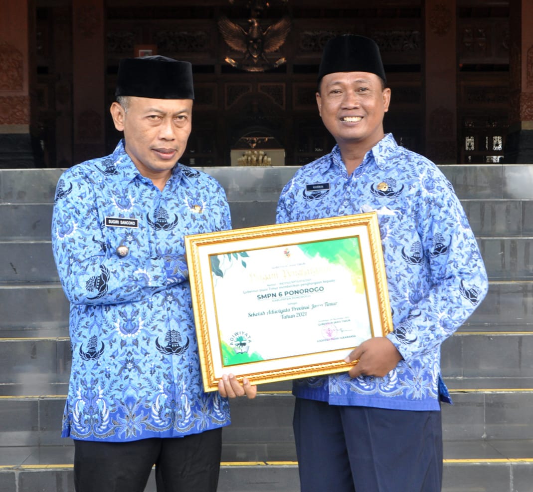 Bupati Ponorogo menyerahkan piagam penghargaan kepada pemenang lomba Adiwiyata tingkat Jawa Timur, Kusnin,S.Pd, M.Pd. 
di halaman pendopo kabupaten Ponorogo