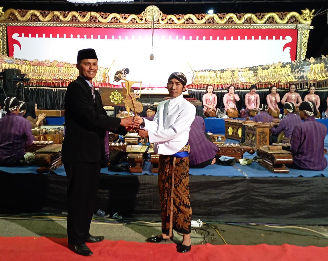 Kepala Desa Ngasinan Anis Muhtarom, S.Sos menyerahkan wayang ke Ki Sigid Ariyanto, S.Sn dari Rembang 