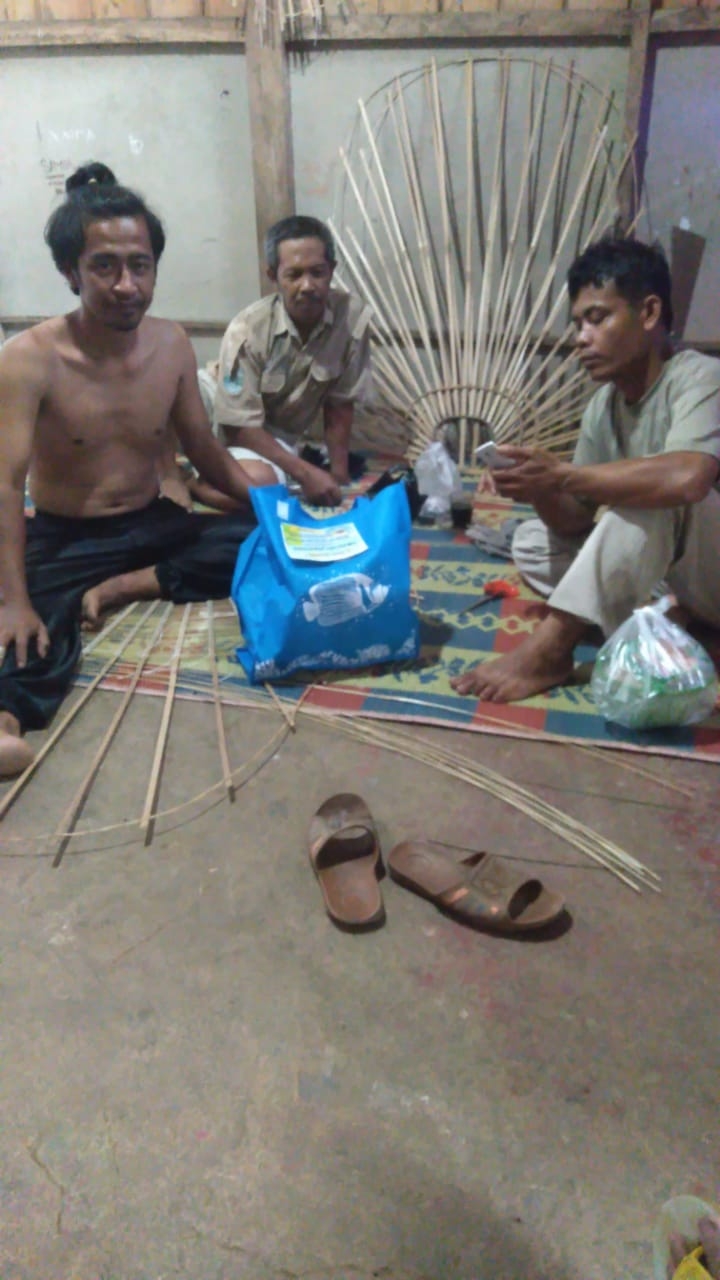 Hian Wijaya saat mengerjakan kerajinan dan Sarif petugas keamanan LMDH Tani Maju saat bertandang dan menyerahkan bingkisan lebaran ke Rumah Pengrajin Rengkek Reog Mini