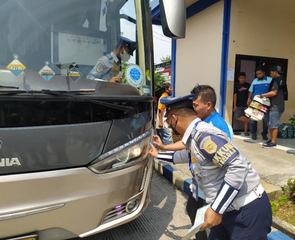 Petugas mengecek lampu bus